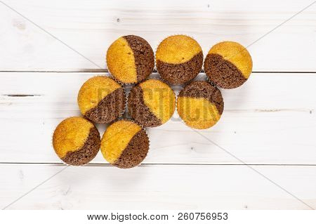 Group Of Eight Whole Fresh Baked Marble Muffin Flatlay On White Wood