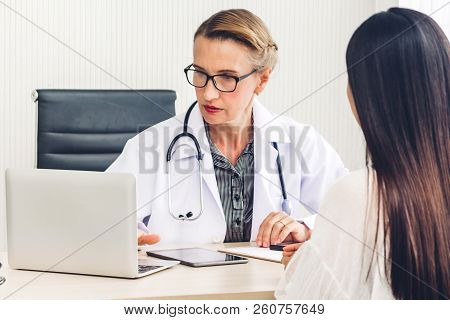 Doctor Discussing And Consulting With Female Patien On Doctors Table In Hospital.healthcare And Medi