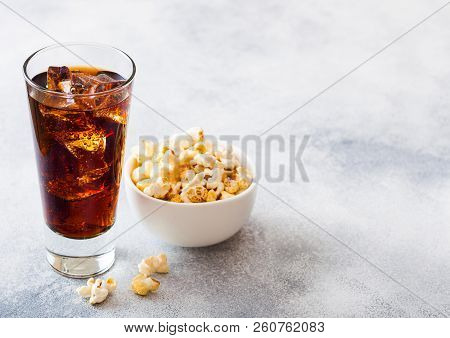 Glass Of Cola Soda Drink With Ice Cubes And Whitel Bowl Of Popcorn Snack On Stone Kitchen Background