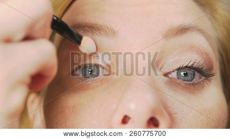 Super Close-up, A Woman Doing Her Eye Make-up, Paints The Eyelid With Shadows.