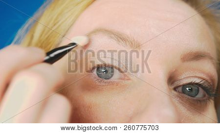 Super Close-up, A Woman Doing Her Eye Make-up, Paints The Eyelid With Shadows.