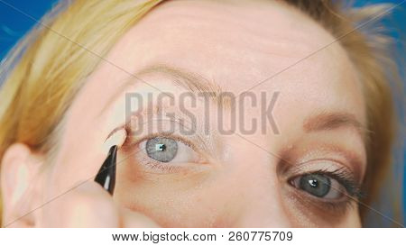 Super Close-up, A Woman Doing Her Eye Make-up, Paints The Eyelid With Shadows.
