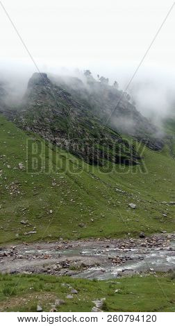 Mountain Slope With Grass Fog Trees On The Rock And River