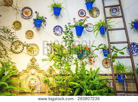 Typical Andalusian Wall Decorated With Plates And Flower Pots , Cordoba, Spain, Toned