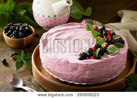 Cake With Black Currant Cream Souffle And Biscuit On A Table In A Rustic Style. Copy Space.