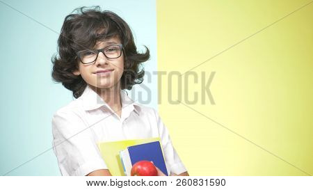 Portraits Of A Teenage Boy In School Uniform On A Colored Background. Funny Guy. Concept Of Learning