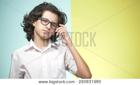 Portraits Of A Teenager In School Uniform And Glasses On A Colored Background. Concept Of Learning. 