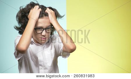 Portraits Of A Teenager In School Uniform And Glasses On A Colored Background. Concept Of Learning. 