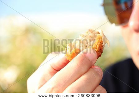 Man Eating A Bitterbal With Mustard, Warm Fried Snack, Served In The Netherlands