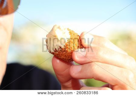 Man Eating A Bitterbal With Mustard, Warm Fried Snack, Served In The Netherlands