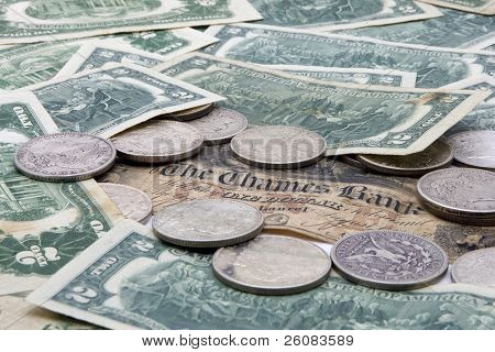 Pilha de duas notas de dólar com dólares de prata