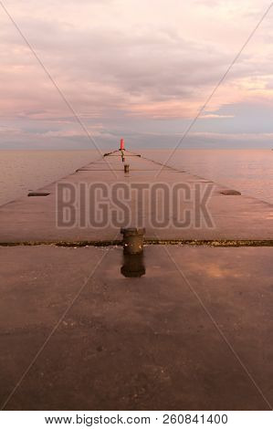 A Lighthouse Pier On Lake Michigan At Sunset With Pink Clouds Reflected In The Water.  Sheboygan, Wi
