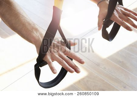 Close-up Of Man Hands Doing Exercise Alone With Fitness Belts In Modern Gym Club, Workout Single Spo