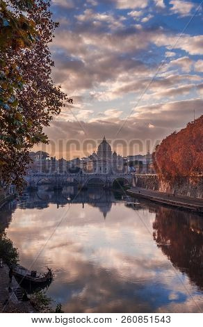 Autumn Leaves Along River Tiber In Rome With Ancient Monuments And Old Sunken Ship At Sunset