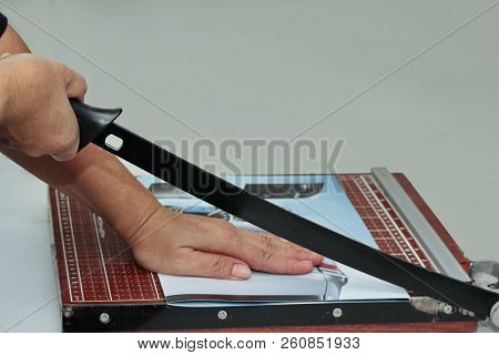 Hands Take To Cut The Paper By Using Wooden Guillotine Paper Trimmer And Cutter