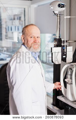 Ophthalmologist Examining Young Man With Optometric Machine In Optics Store