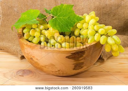 Clusters Of The Ripe White Sultana Grapes With Vine Leaves In Vintage Wooden Fruit Bowl On A Light C