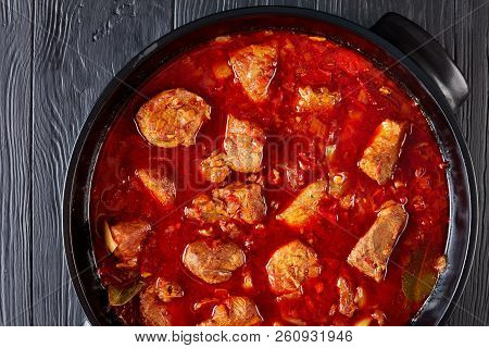 Hearty Red Chile And Pork Stew Or Carne Adobada In A Dutch Oven On A Black Wooden Table, Mexican Cui