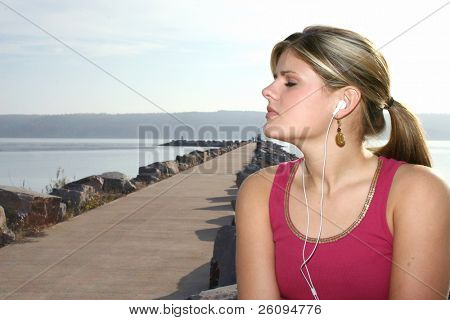 Giovane donna ascoltando musica fuori dal lago.