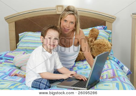 Matka a syn s notebookem v posteli.