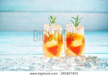 Gin Cocktail With Rosemary And Grapefruit On A Turquoise Backgro