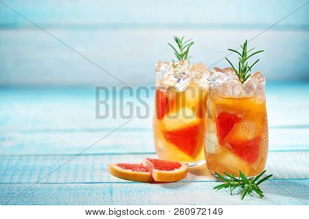 Gin Cocktail With Rosemary And Grapefruit On A Turquoise Background, Selective Focus.