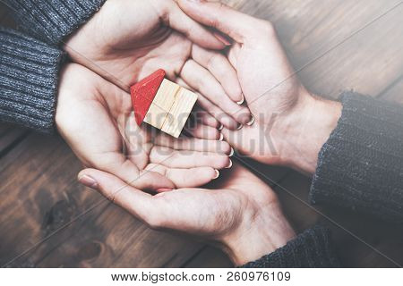Pisture Of Man And Woman Hands Holding House Model