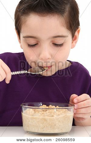 Adorabile cinque-anno-vecchio ragazzo mangiando ciotola di farina d'avena.