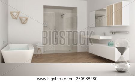 White Table Or Shelf With Crystal Hourglass Measuring The Passing Time Over Blurred Modern Bathroom 