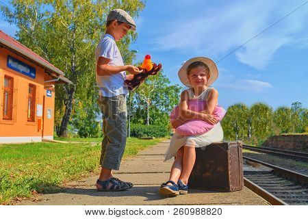 Little  Children - Girl And Boy On A Railway Station, Waiting For The Train With Vintage Suitcase. T