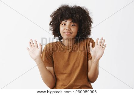 Woman Deying Her Resonsibility Raising Hands In Surrender And Smiling With Sorry Look Being Uninvolv