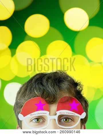 Portrait Of Cheerful Man In Christmas Glasses. , Attractive Man On Green Sparkles Background With Co