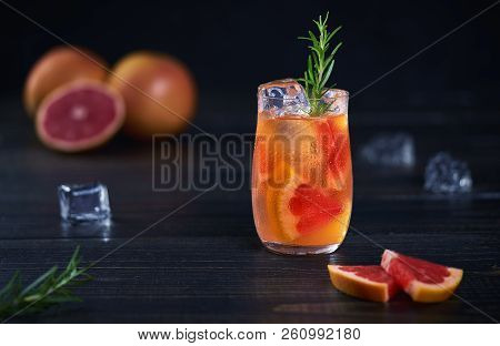 Refreshing Cold Cocktail With Grapefruit And Rosemary On A Black