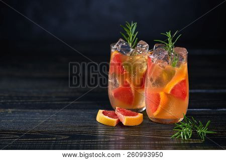 Refreshing Cold Cocktail With Grapefruit And Rosemary On A Black