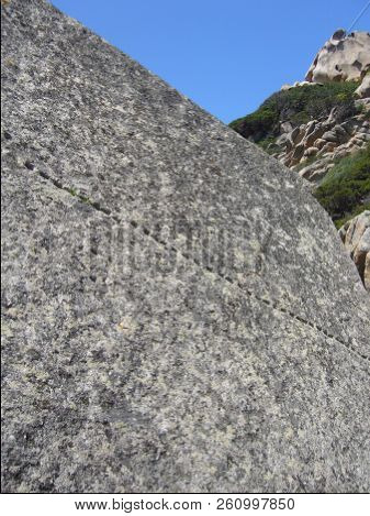 Granite Rocks Closeup, Natural Texture Pattern With Blue Sky In The Background