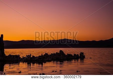 Beautiful reflection. Red sunset. Picturesque Mono lake. The columns-remains of bizzare shapes of 