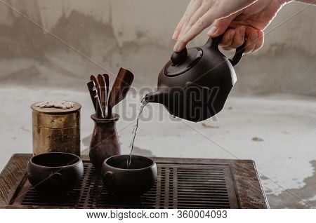 Cropped Shot Of Woman Pouring Tea In Traditional Chinese Teaware