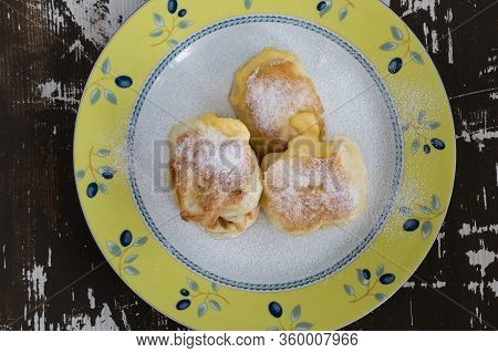 Top View Of Fried Fritters Sifted By Sugar Powder On Plate On Wooden Background