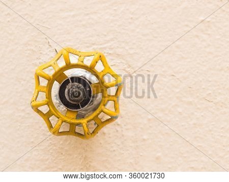 Yellow Faucet Front View Isolated On Soft Backlight. Hydraulic Valve.