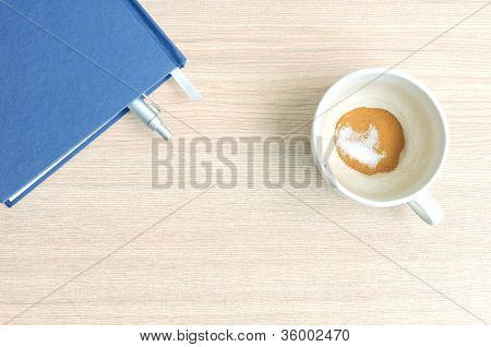 Kaffeetasse und Bood auf einem Holztisch