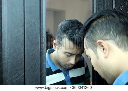 A Man With Head Down In Front Of A Mirror In Depressed Mood With Selective Focus On Mirror Image
