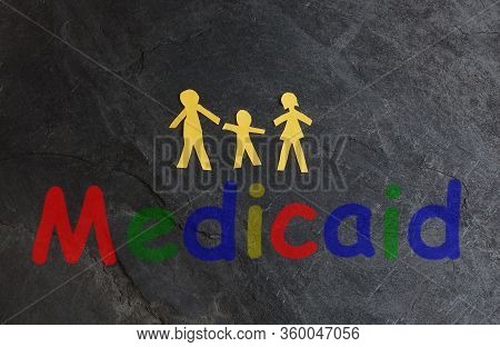 Paper Family Of Three With Colorful Medicaid Text On Textured Surface