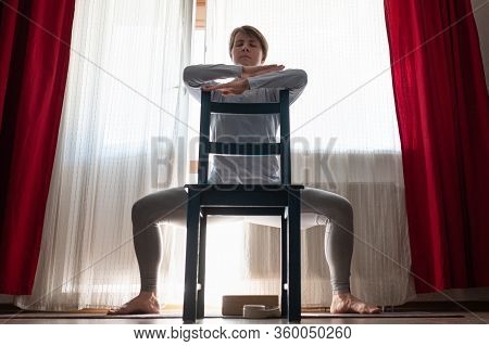 Girl Doing Goddess Pose Temple Or Sumo Pose, Stupasana, Using Chair