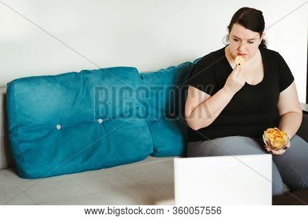 Mindless Snacking, Home Sedentary Lifestyle, Compulsive Overeating. Obese Lazy Woman Sitting On Sofa