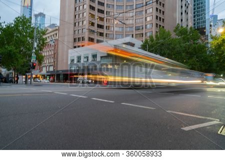 Pace Of City Life Implied But The Motion Blurs And Light Trails Of Passing Trams And Vehicles In Mel