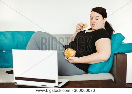 Mindless Snacking, Home Sedentary Lifestyle, Compulsive Overeating. Obese Lazy Woman Sitting On Sofa