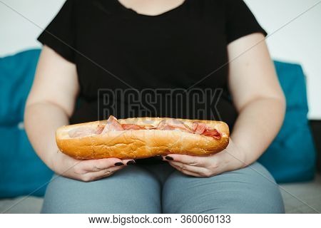 Overeating And Gluttony Concept. Mindless Snacking, Home Sedentary Lifestyle. Obese Woman Sitting On