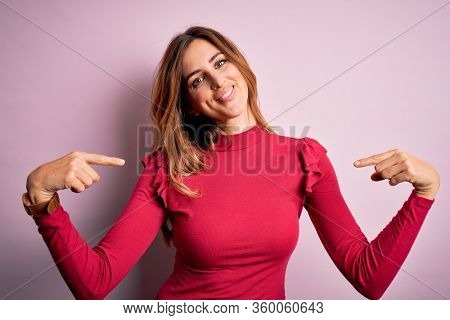 Young beautiful brunette woman wearing casual sweater stnding over pink background looking confident with smile on face, pointing oneself with fingers proud and happy.