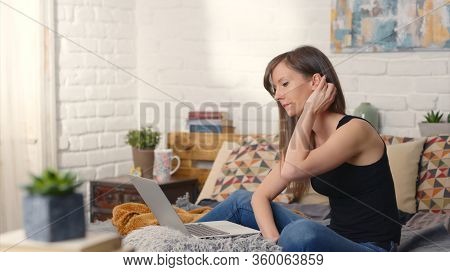 Stay at home and work in home office - Casual woman sitting on bed working online from home with laptop computer.