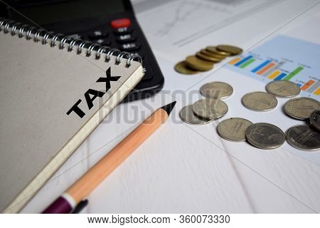 Tax Write On Book On Clipboard And The Stack Of Coint. Finance Or Tax Concept